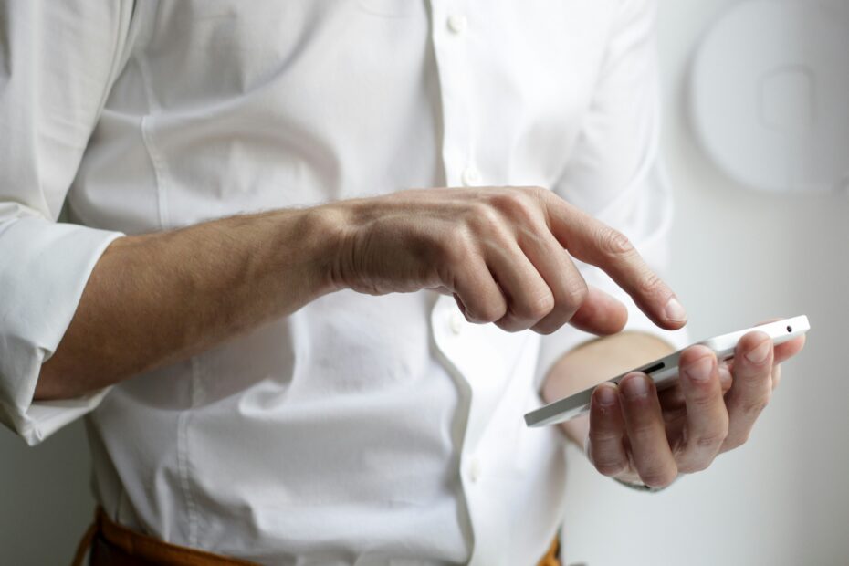 Hand holding a smartphone displaying a poker app interface