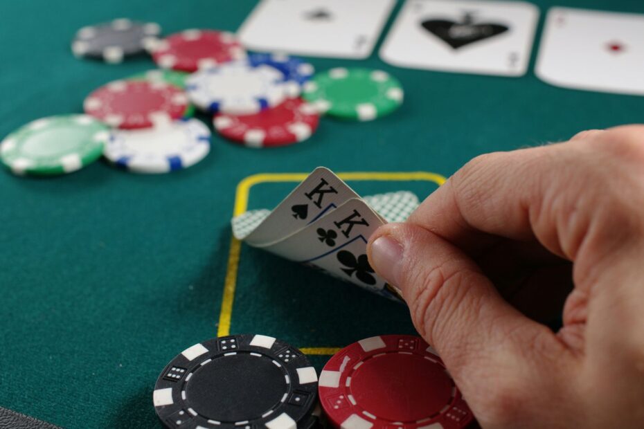 Hand holding playing cards at a poker table