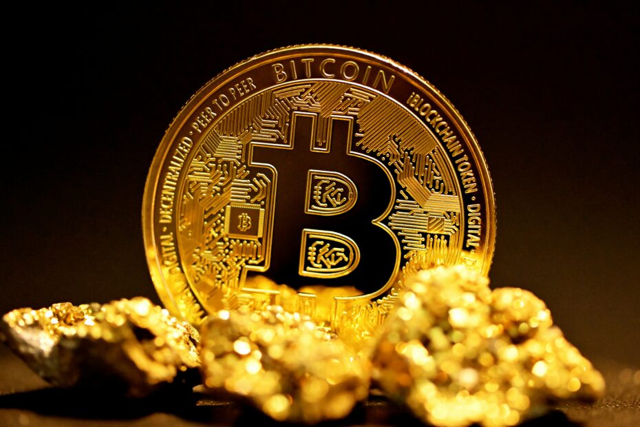 Gold bitcoin coin resting against gold nuggets