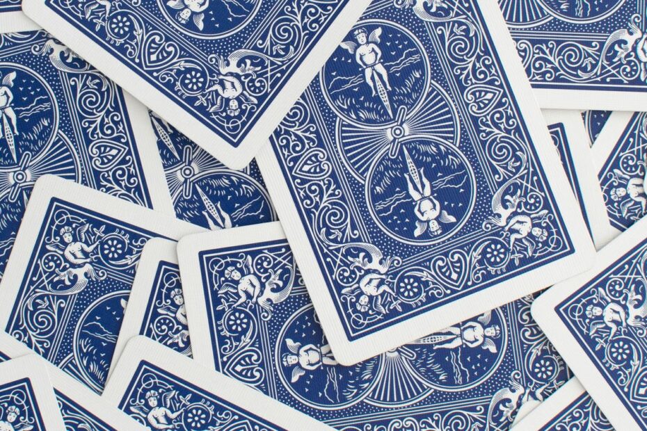 Face-down blue playing cards scattered across a table, representing the many possible hands an opponent could hold