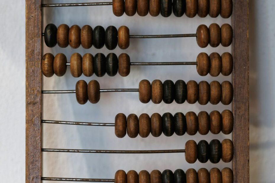 Close-up of a wooden abacus with dark and light beads on metal rods, a symbol of counting odds and outs in poker