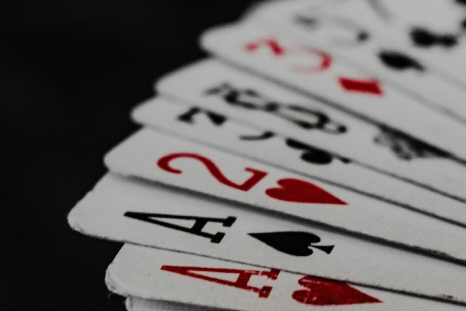 Close-up of fanned playing cards on a dark table, a visual for the short deck card order
